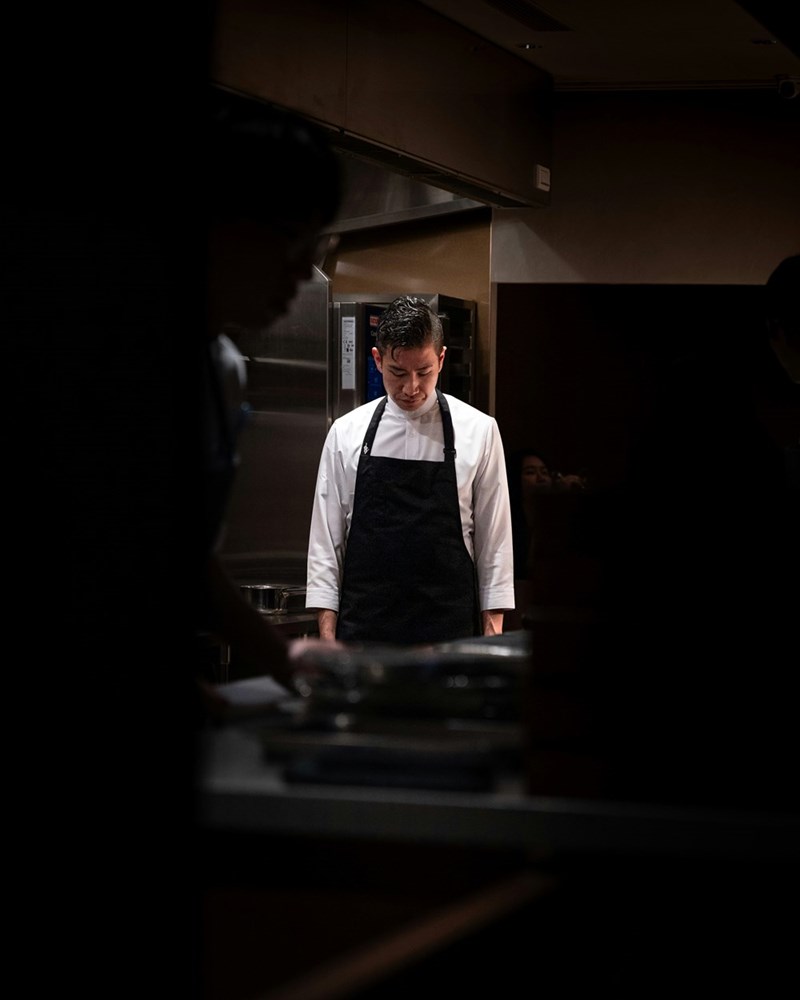 A chef looks dejected and exhausted after a busy shift.