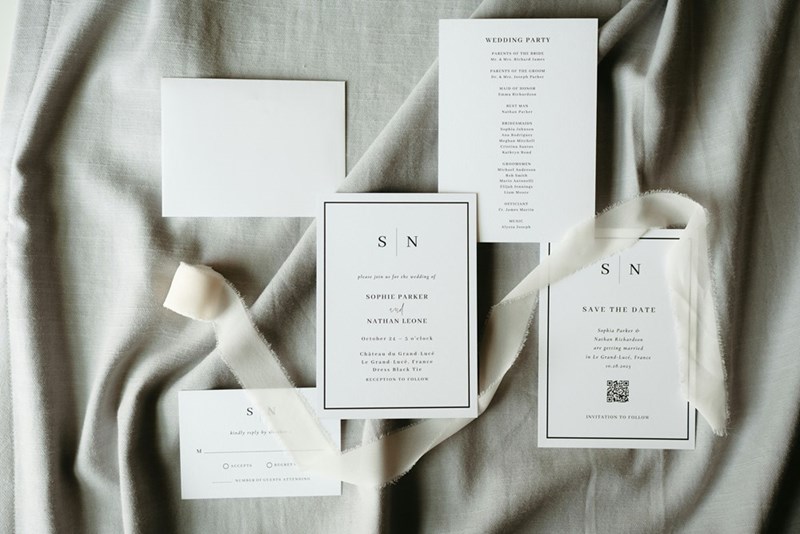 Elegant wedding invitation suite displayed on soft fabric with RSVP cards and event details.