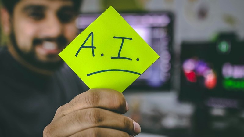 A sticky note with the letters “AI”