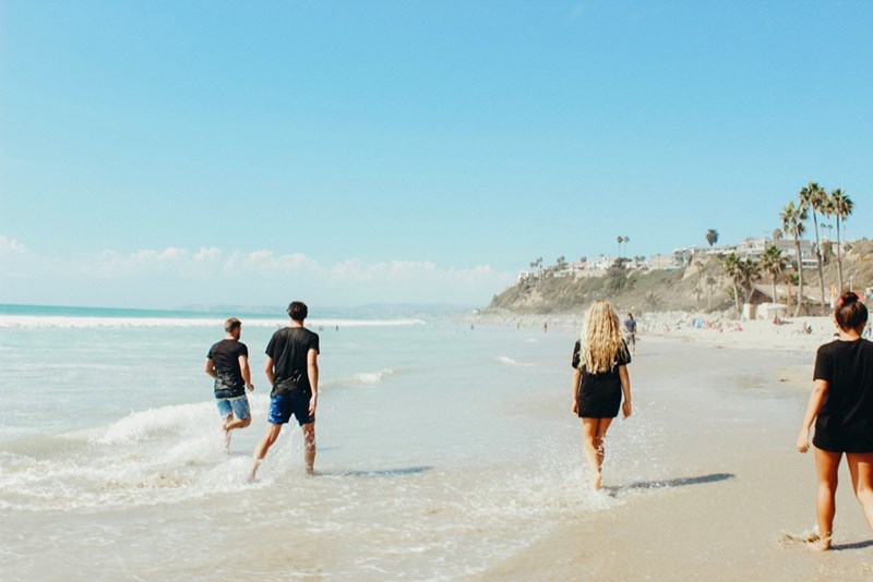 Friends having fun at a beach, model image.