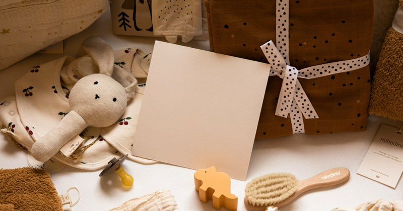 A collection of neutral-colored baby clothes, toys, gifts, and fabrics