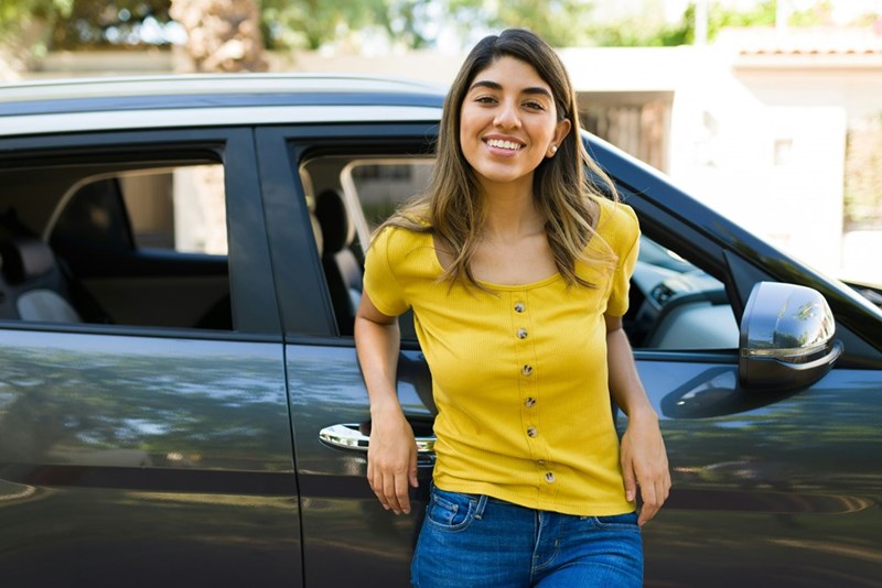 This model depicts a woman standing in front of her car, representing a driver who feels disrespected after giving someone regular rides to work.