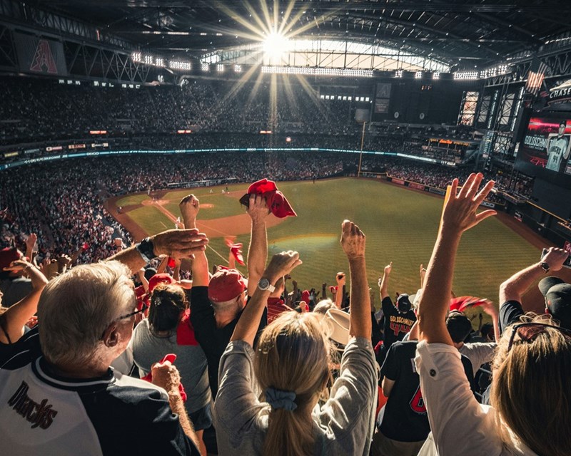 A crowded baseball stadium at dusk, showing the game a man attended instead of his anniversary dinner.