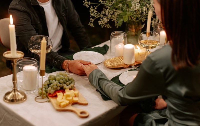 An illustrative image of a couple on a date at an elegant restaurant, representing the anniversary dinner a fiancée expected to share with her partner.