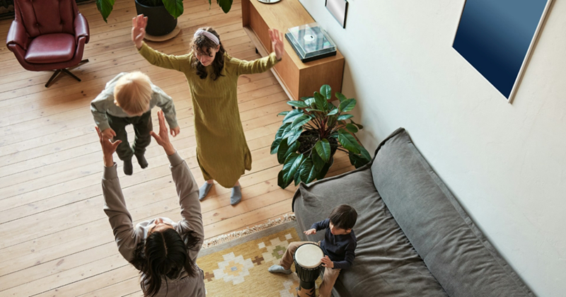 An overhead view of a mom playing with three kids of different ages in a living room