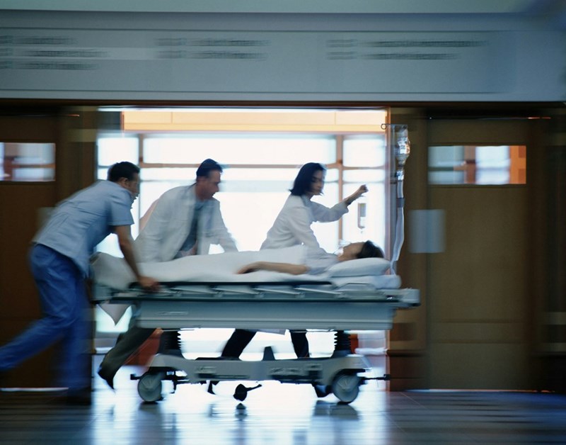 Doctors and nurses rushing a patient through the hospital hallways after he arrived to the Emergency Room in critical condition