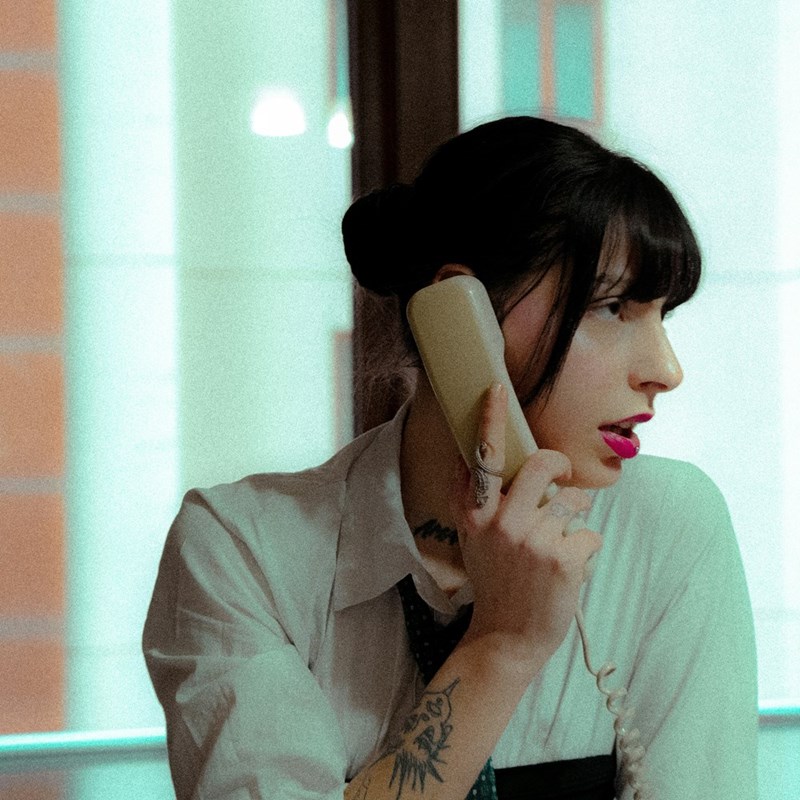 a woman in a white shirt talking on a phone