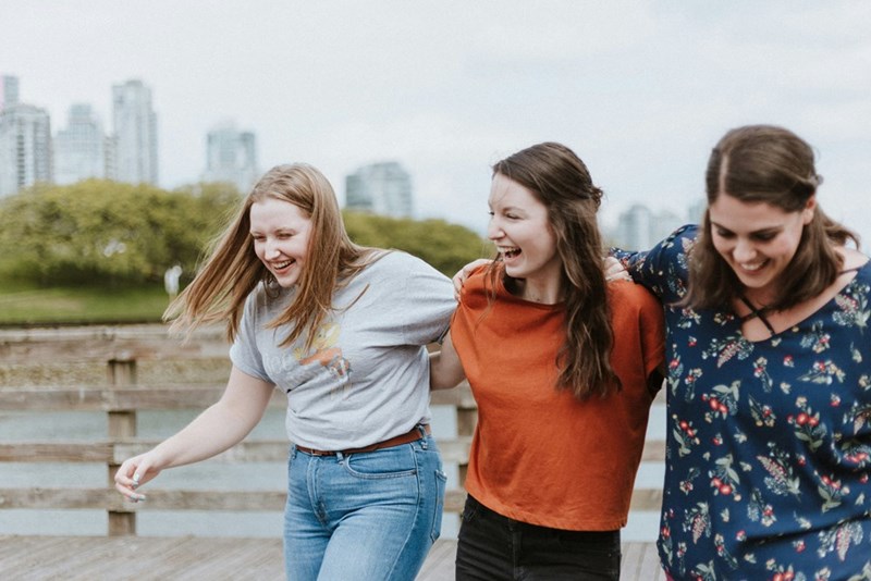 three women walking and laughing