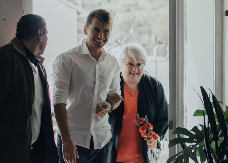 A young man and his grandmother walk arm in arm, not actual story subjects.