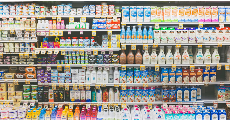 An array of dairy products on refrigerator shelves in a grocery store