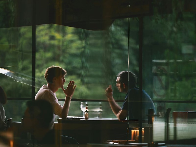 Two men sitting across from each other, talking.