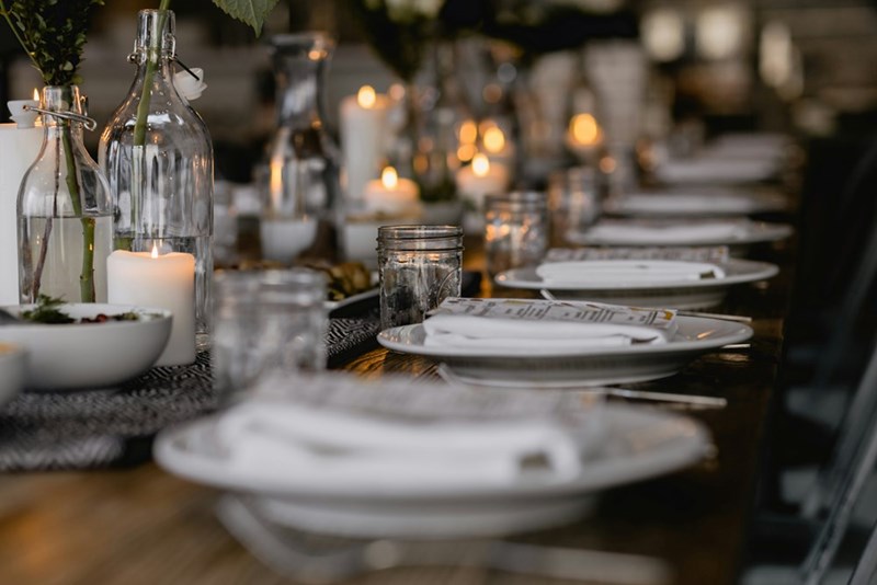 Visual representation of plates and glasses being set on a table at a restaurant.