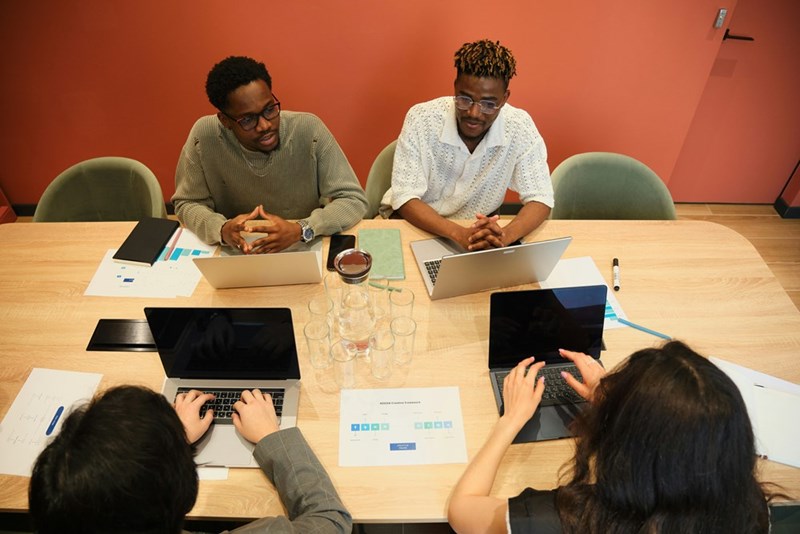 This model illustrates university students working together with laptops, representing academia, research, and a professional identity built over time.