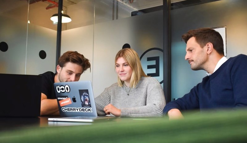 Coworkers work on a project together, representitive of the team in this story.