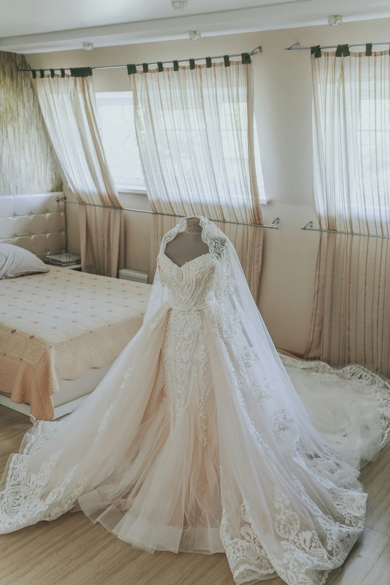 A traditional wedding dress stands ready for a ceremony, symbolizing family traditions, memories, and competing expectations.