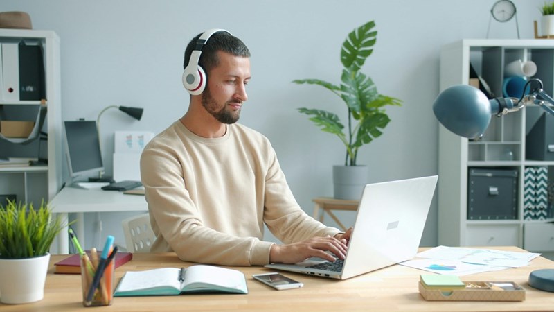 man wearing headphone working on laptop