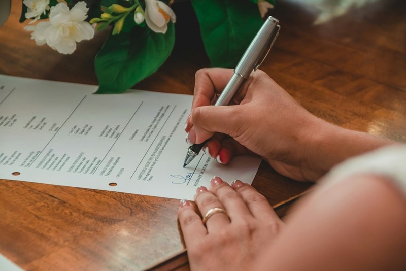 a bride signing marriage papers