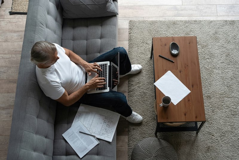 Professional works from a living room workspace after trading daily commutes for a home office routine.