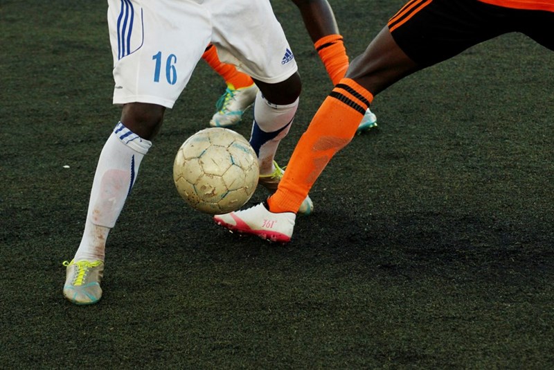 Players playing football, representation.