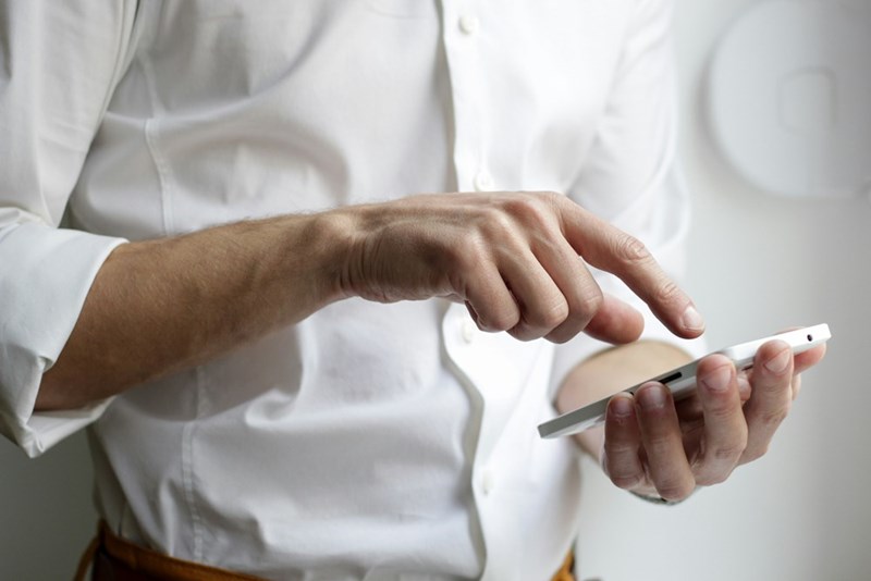 A man using his phone, representation.