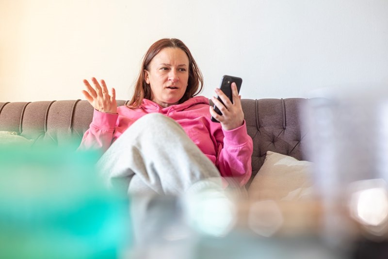 A woman reacting to her phone with a baffled, defensive look, like a simple sale has turned into an argument