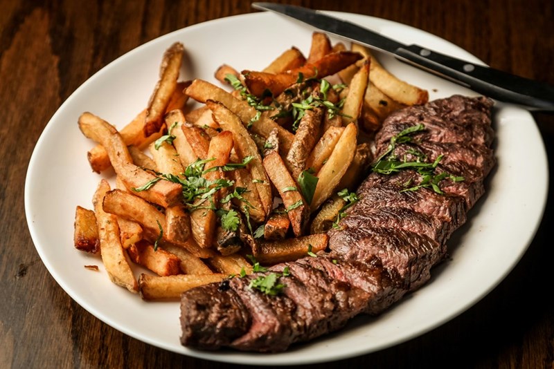 A steak with fries, representing the shared restaurant meal behind a couple’s argument about stolen fries.