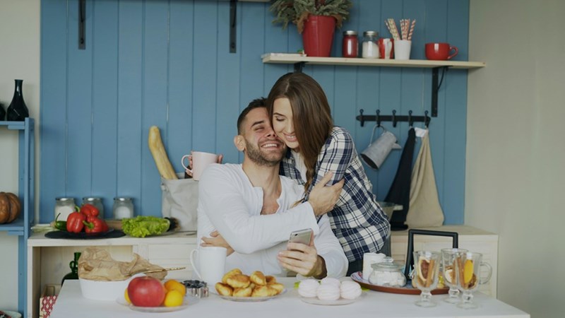 Couple smiling and hugging in the kitchen.