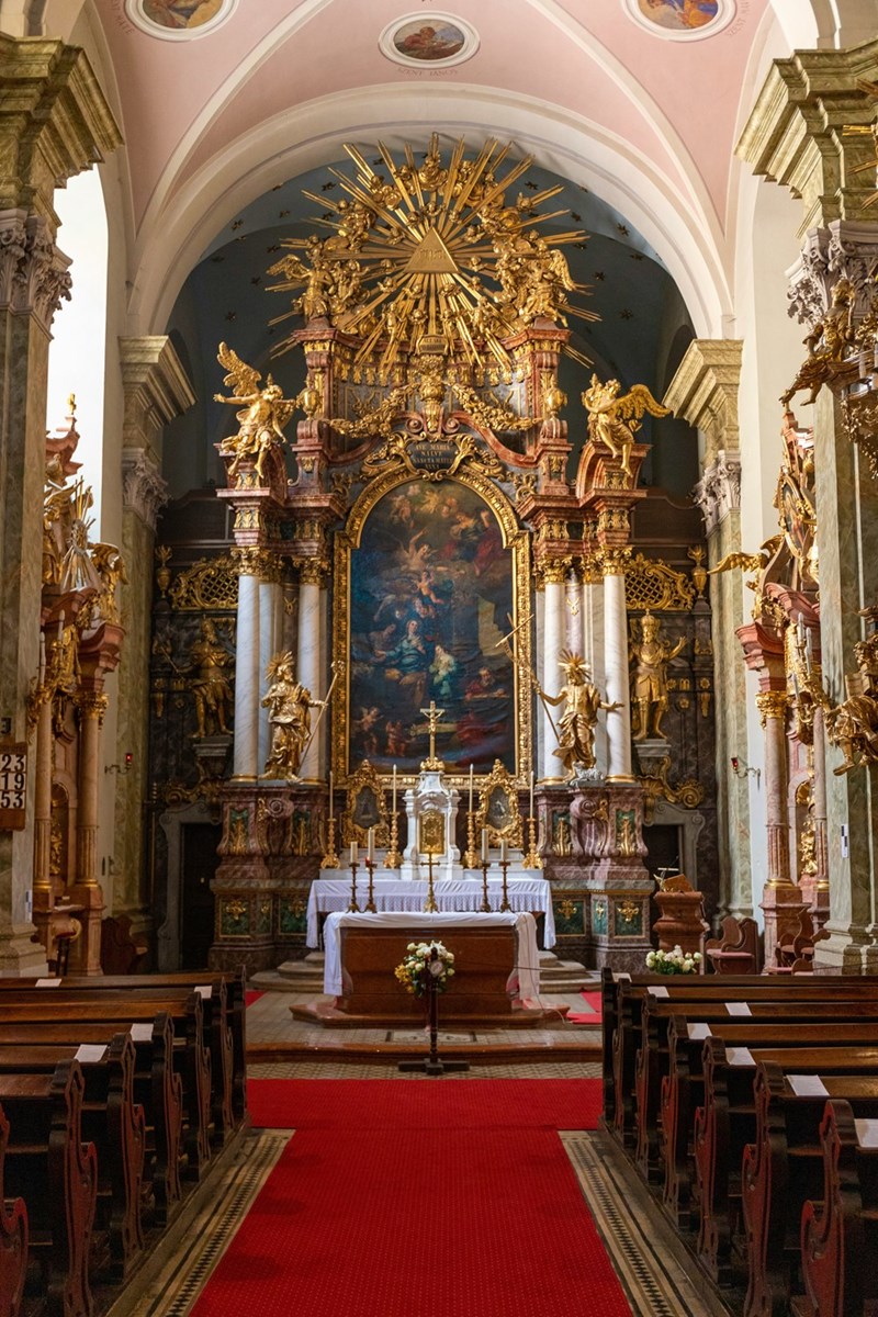 a church with a red carpet and gold altar