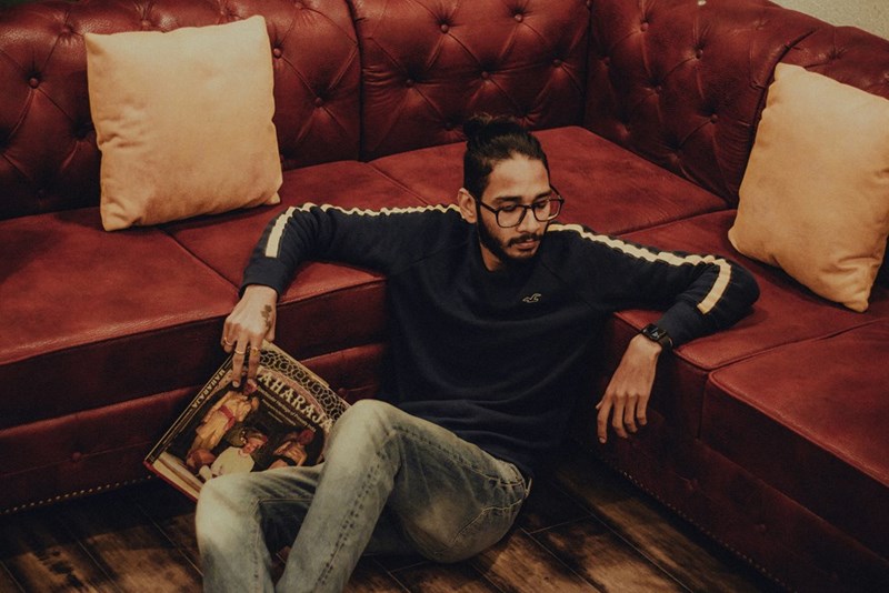man sits on the floor besides sofa