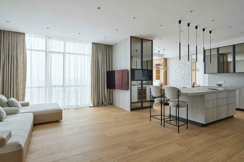Spacious modern home interior with an open-concept kitchen, living area, and large windows.
