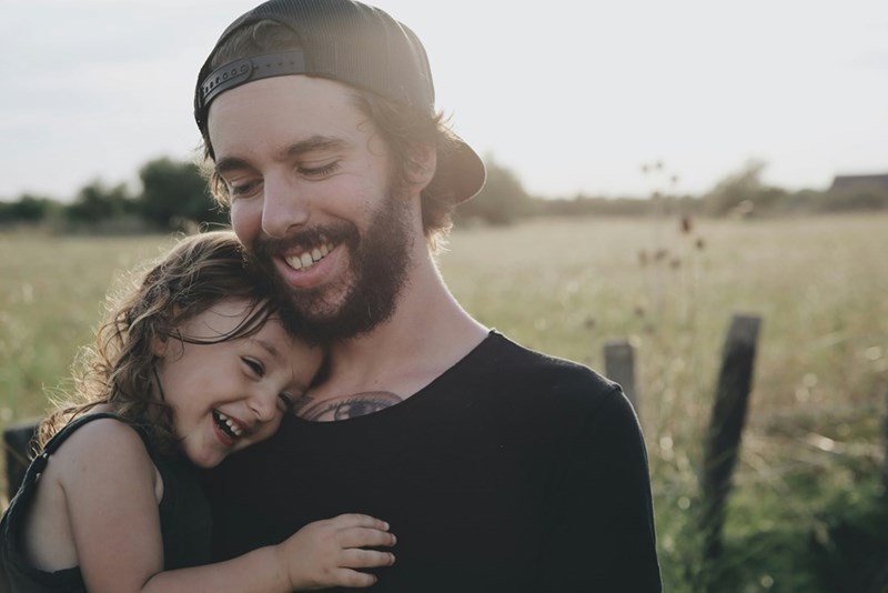 A father and a daughter hugging, model image.