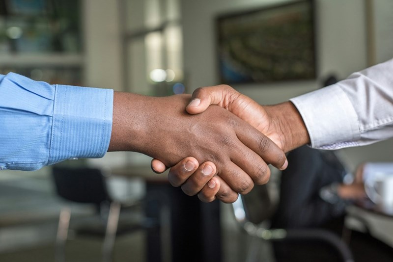 Two people holding hands to show they are closing a deal.