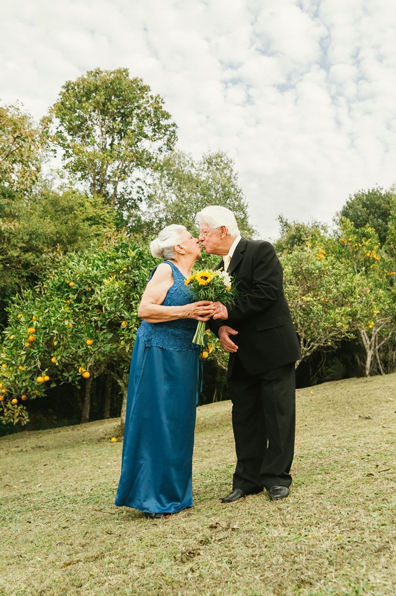 A grandmother wearing blue kisses her husband, representing the “something blue” that every bride needs on her wedding day.