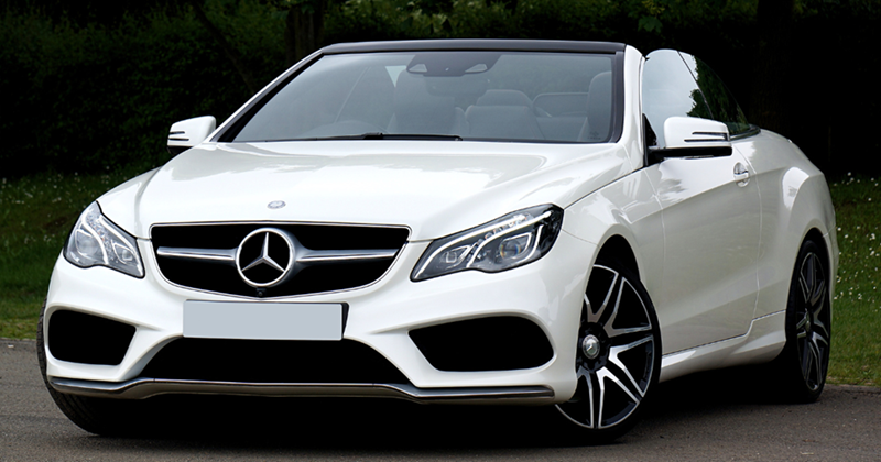 White Mercedes Benz Parked on the pavement.