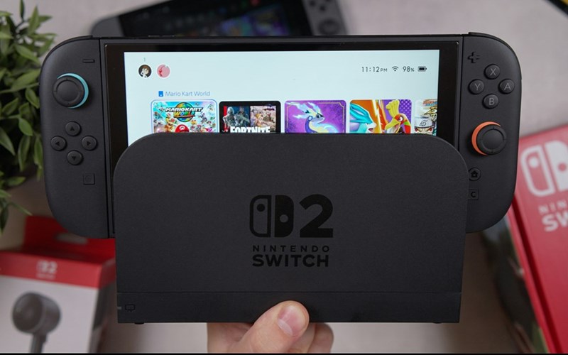Close-up of a Nintendo Switch 2 console in its dock, with game icons visible on the handheld screen.