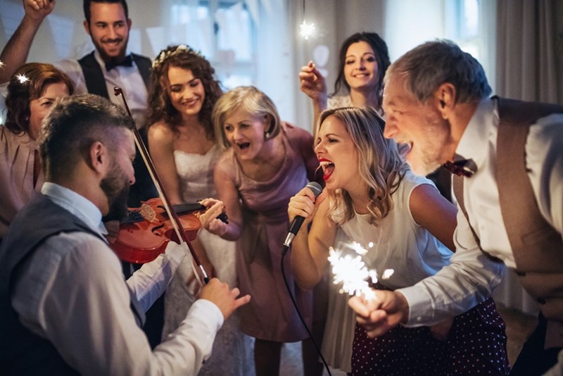 A group of happy wedding guests enjoys themselves at a wedding. 