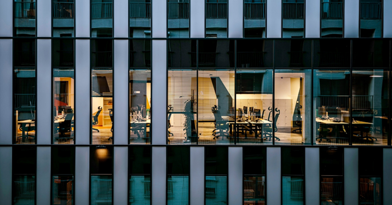A close-up of the outside of one floor of a high-rise glass office building