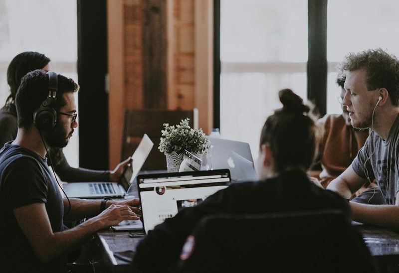 group of people working together with laptops