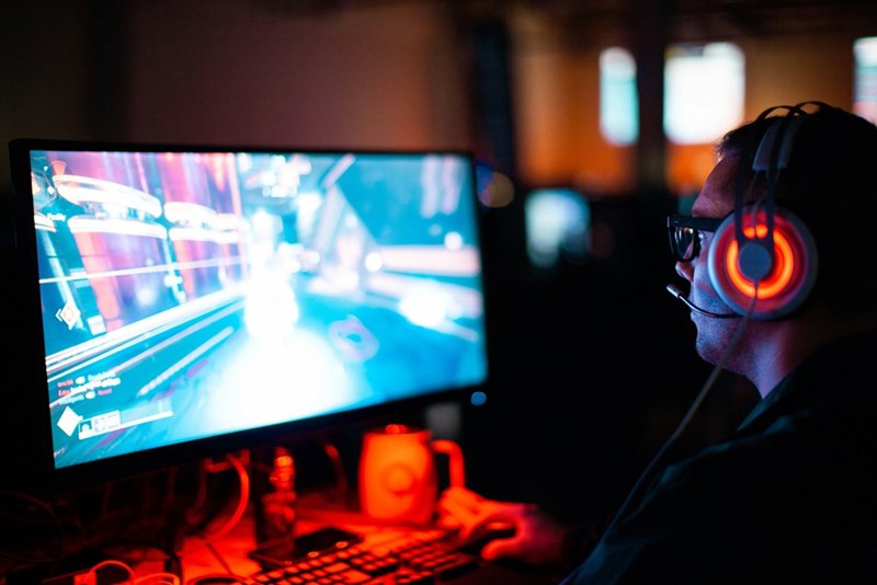 PC gamer wearing a headset playing multiplayer games online, representing the boyfriend’s use of aimbots and wallhacks..