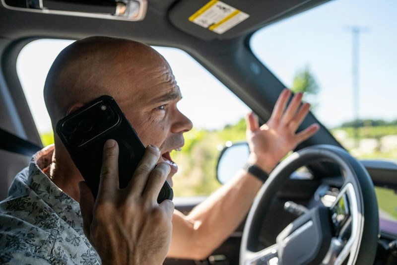 Frustrated caller reacts angrily while trying to get directions during a stressful commute.