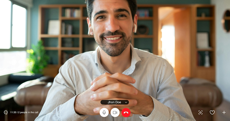 A representation of a man smiling and clasping his hands together while wearing AirPods on a video call