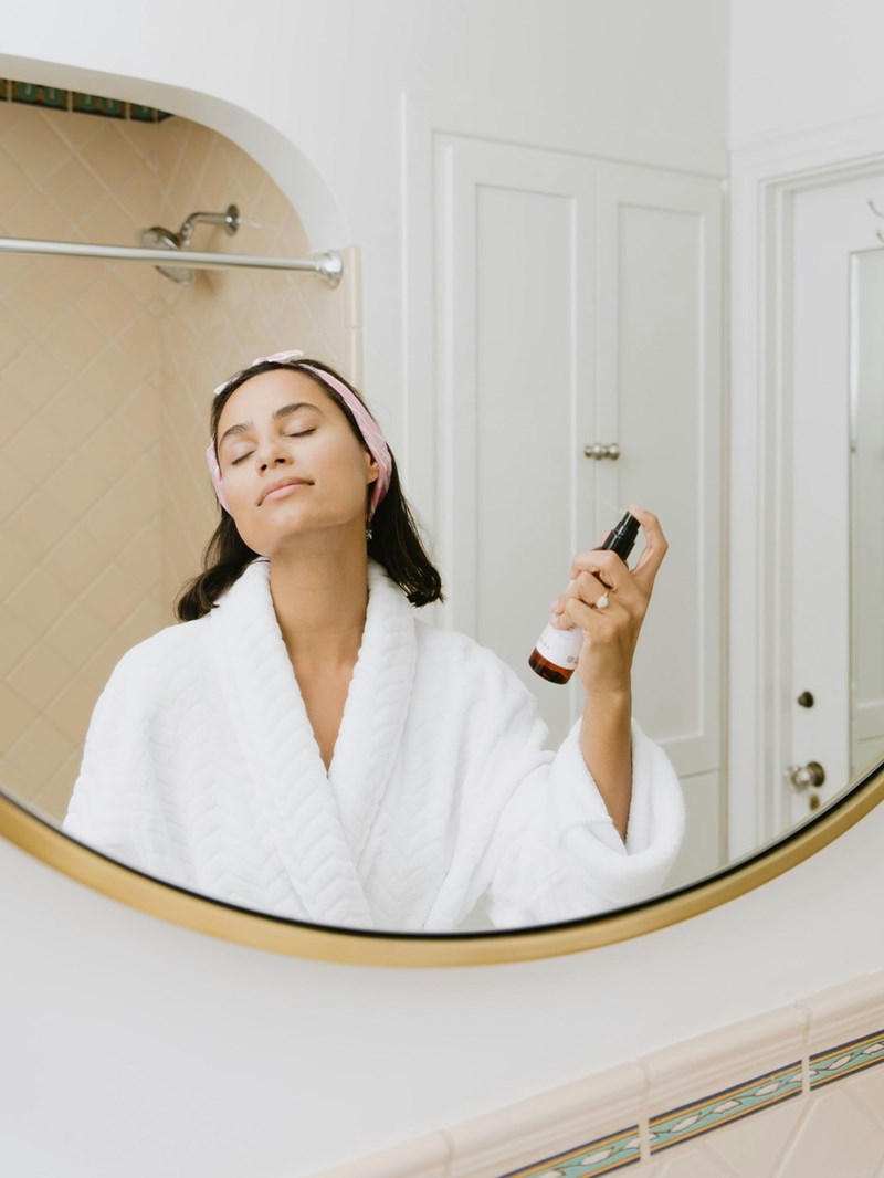 woman in white bathrobe doing her skincare