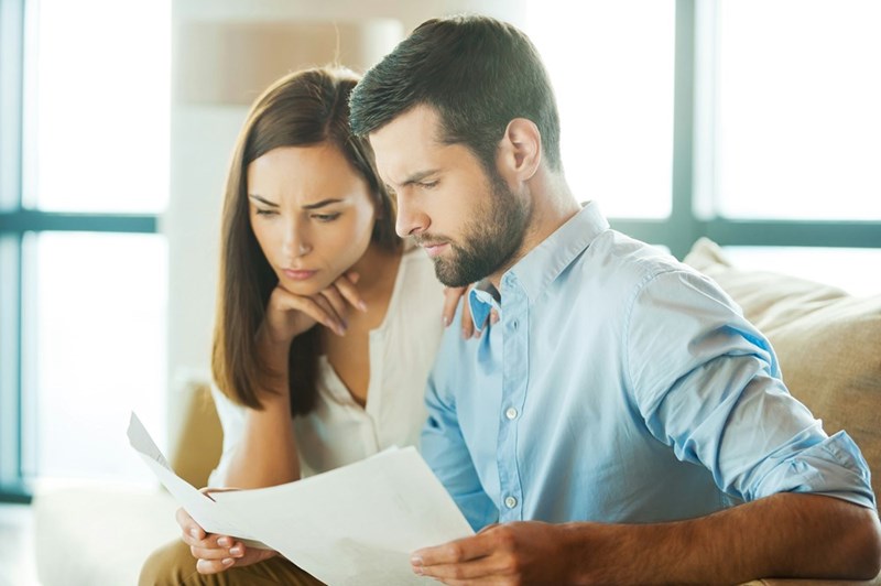 Homeowners reviewing documents related to a property line dispute.