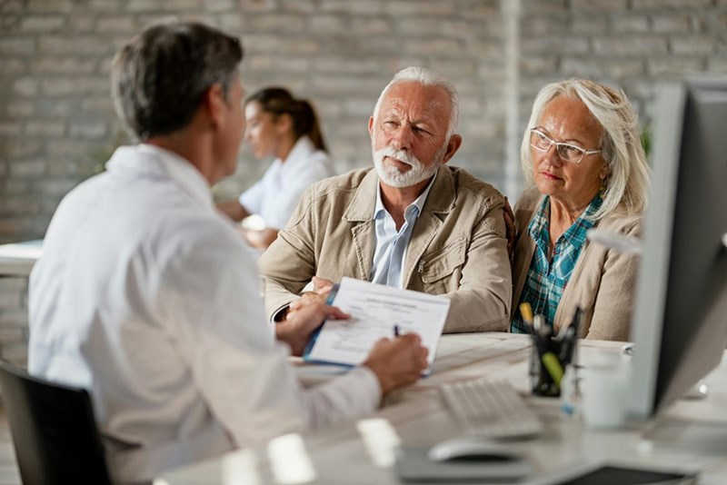 Older couple discussing inheritance and estate planning options with a financial advisor.