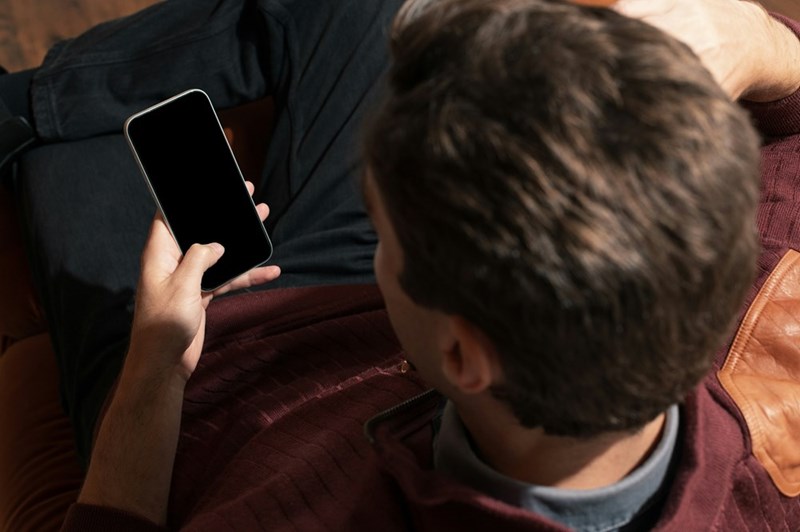 Employee checking his phone while enjoying a day off, reflecting the growing debate over after-hours work expectations.