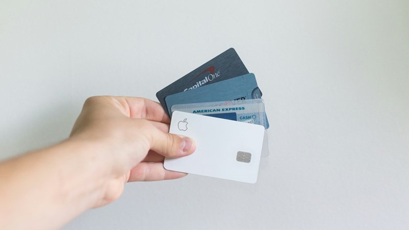 Visual representation of different credit cards being held by a person.