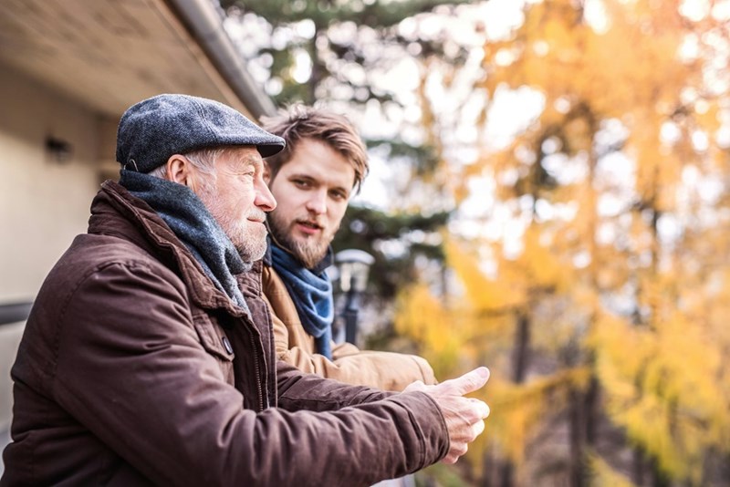 A man talks to his girlfriend's father on the porch