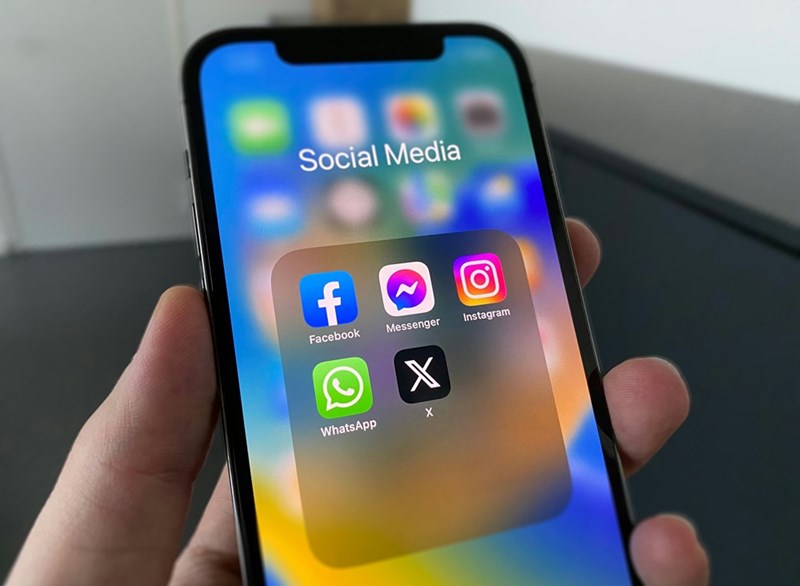 a person holding a cellphone with social media in it