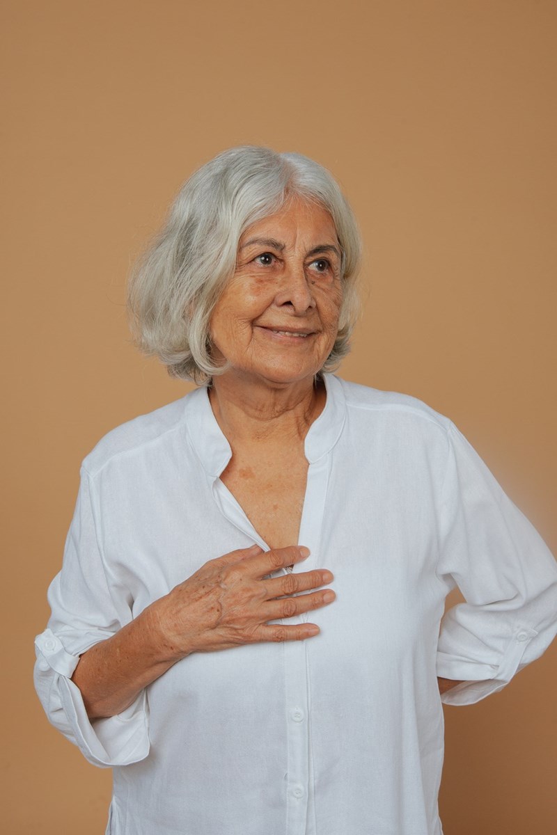 Elderly woman standing thoughtfully as a neighborhood relationship becomes more complicated than expected.