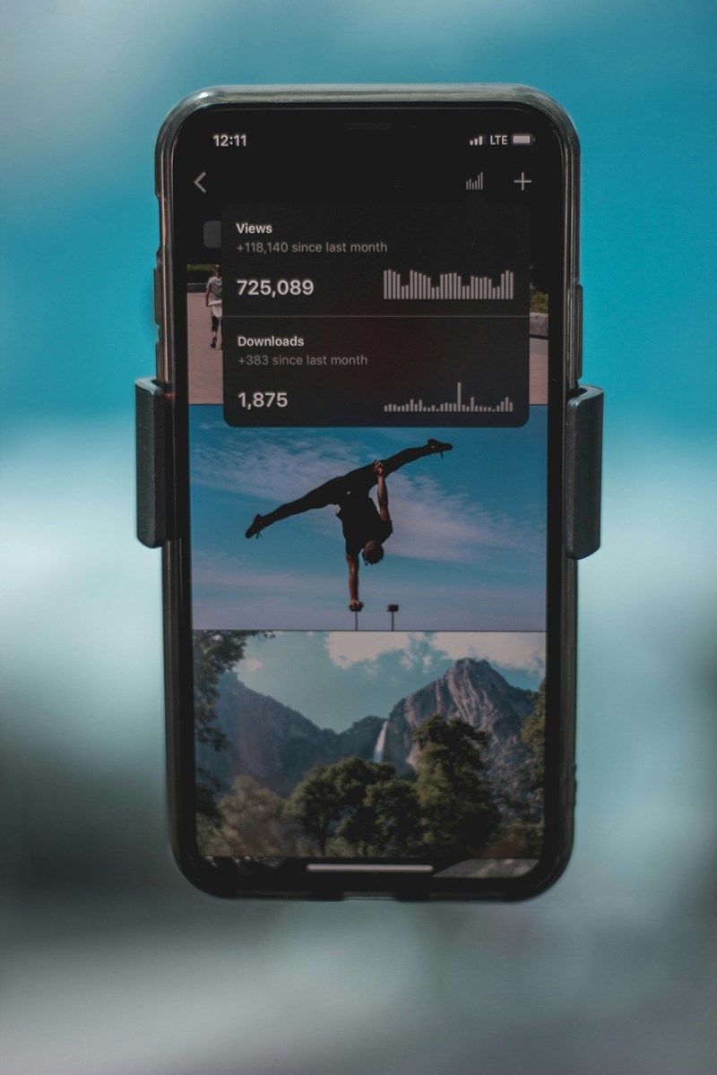 A person doing a trick on a cell phone with statistics of views on the side.